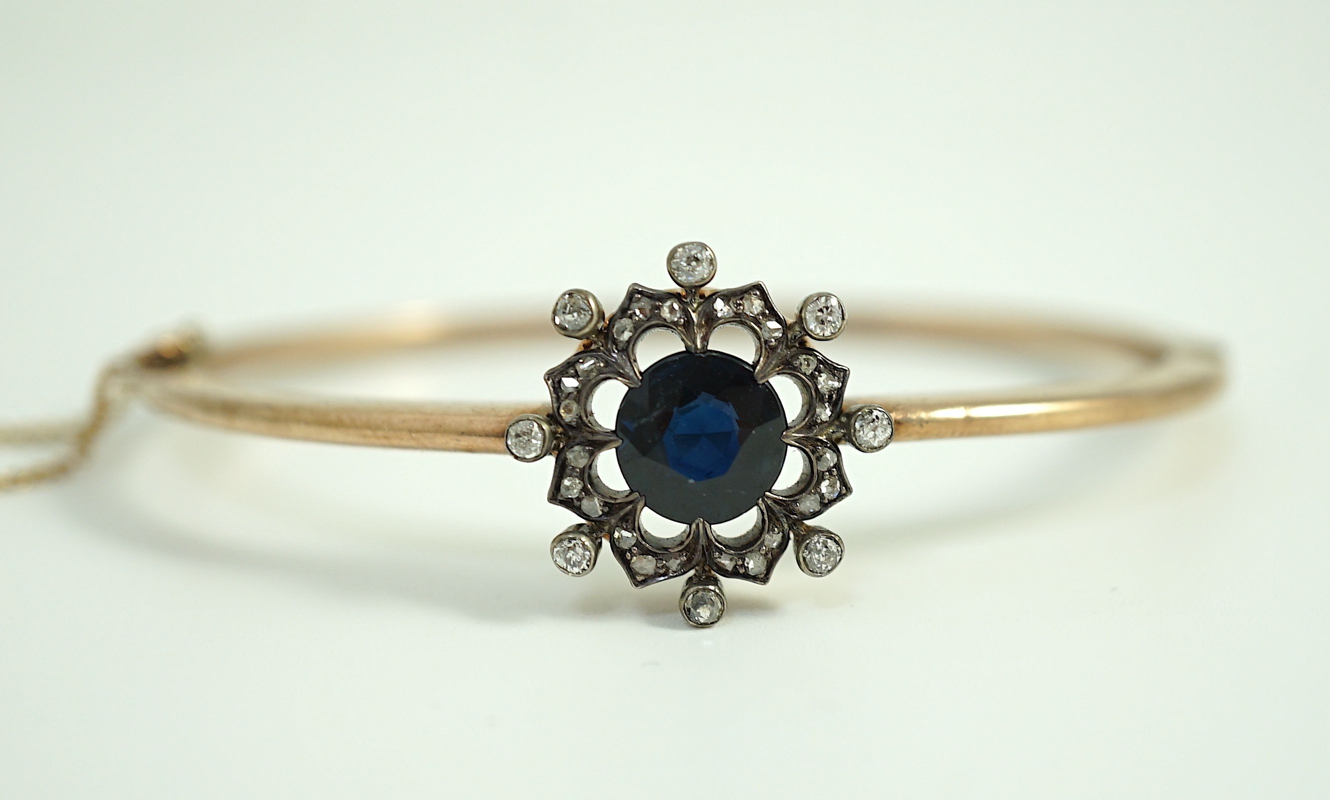 A Victorian gold, sapphire and diamond cluster set hinged bangle